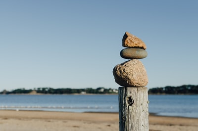 靠近水体的木柱上的岩石平衡